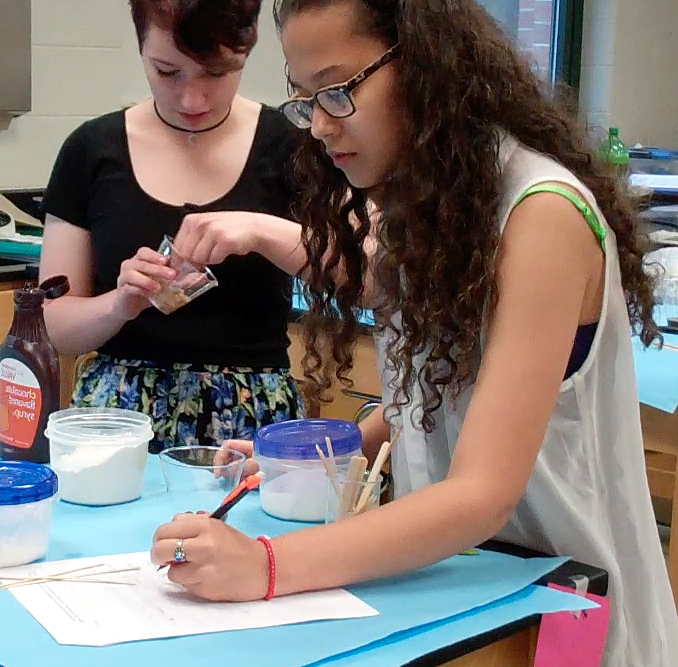 two high school female students collaborating on a science experiment