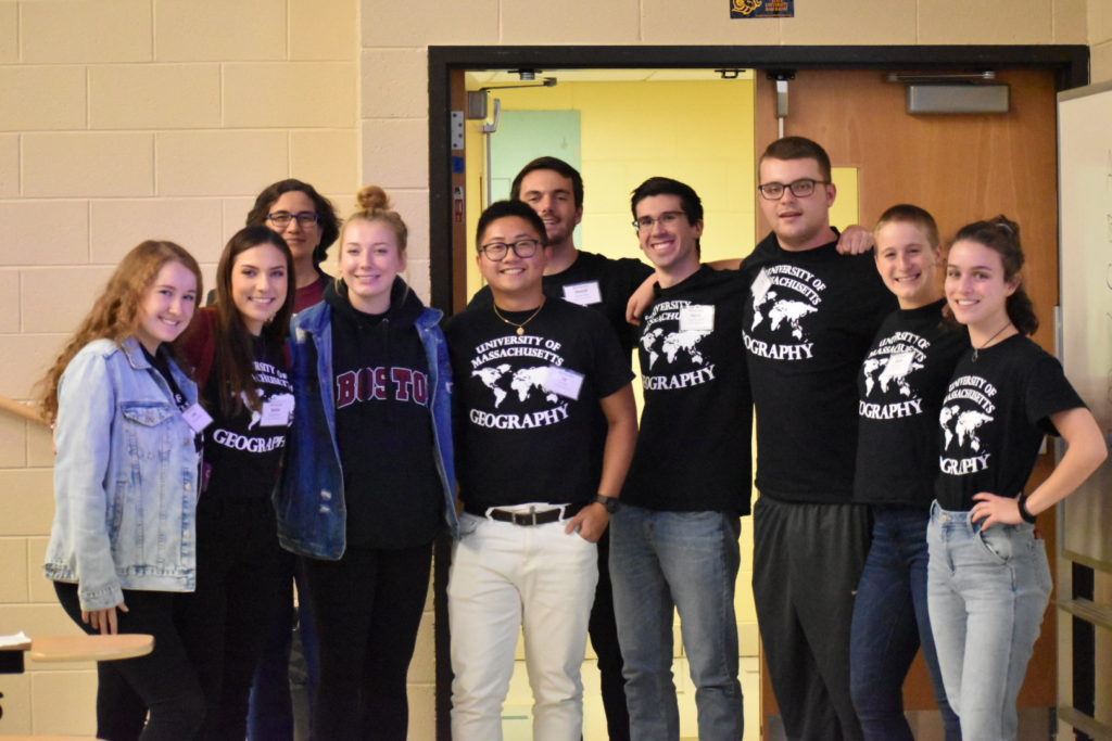 From left to right, Julia Schiemann, Kelsie Butler, Dr. Eve Vogel, Ellen Fay, Le Tran, Dan Finn, Harry Chernin, Mark Doherty, Molly Autery, and Izzy Mezzina gather for a group photo at NESTVAL wearing matching black and white UMass Geography shirts!