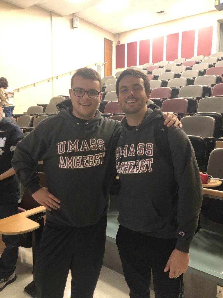 Two UMass Students, Mark Doherty and Daniel Finn, stand next to each other in matching gray UMass sweatshirts after just finding out they were in the top six of scorers in the competition.
