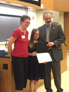 Christina receiving a certificate of completion for her research program, with Dr. Warren and her program leader.